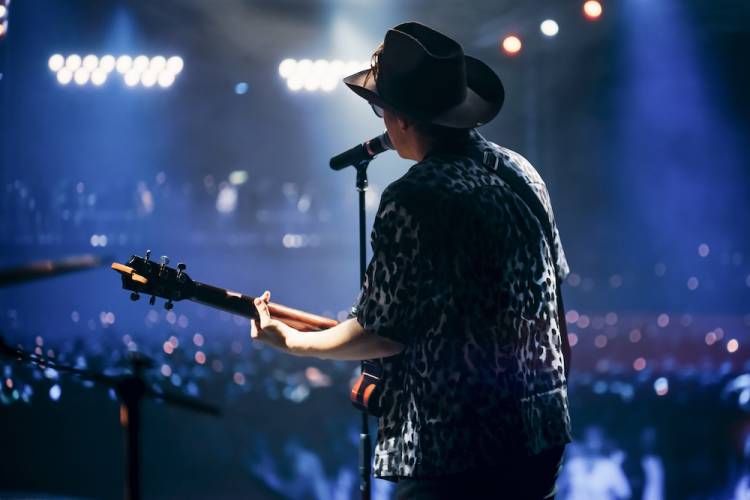 Portrait of a Handsome Young Man Singing a Country Song and Playing Guitar at a Music Festival.
