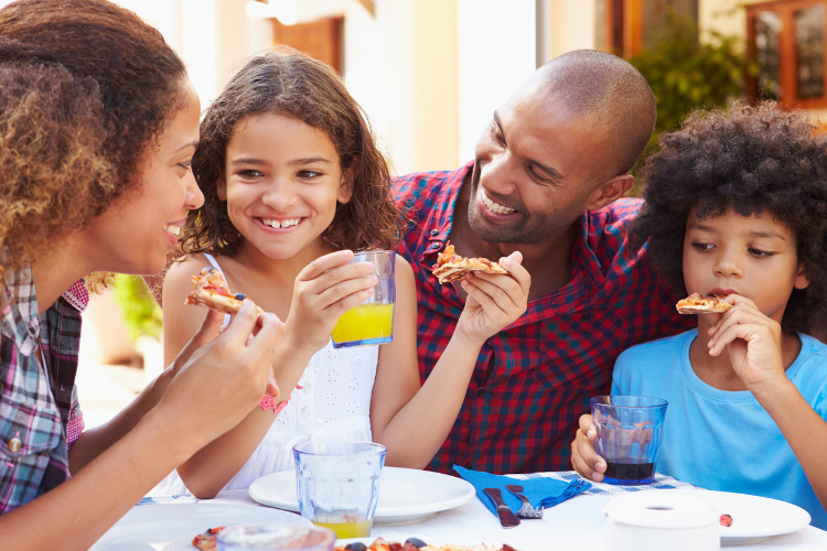 family eating pizza at restaurant