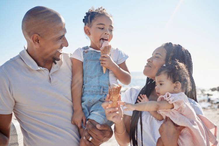 beach and ice cream with children and parents on sand by the sea or ocean during summer together